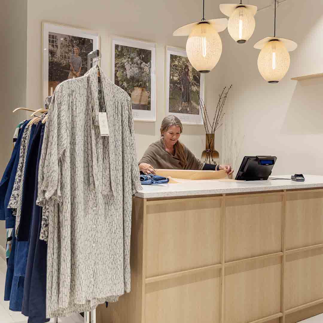 Employee from Masai in Frederiksberg standing at the register.